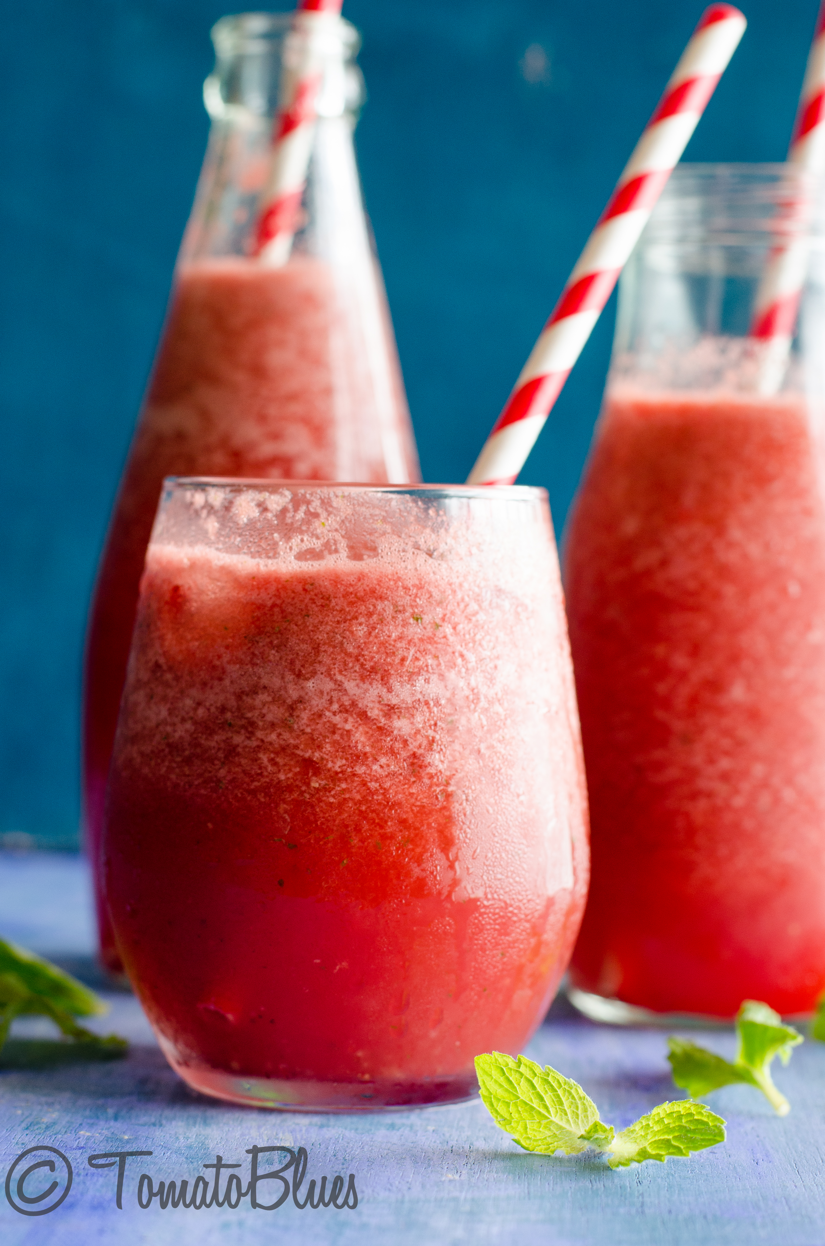 mexican watermelon agua fresca served in glasses and bottles with red and white straws