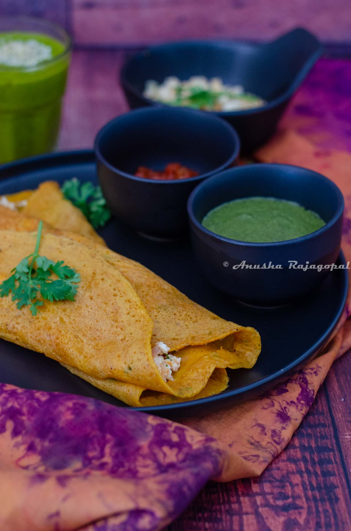 Moong dal cheelas stuffed with paneer and served with chutneys and a smoothie