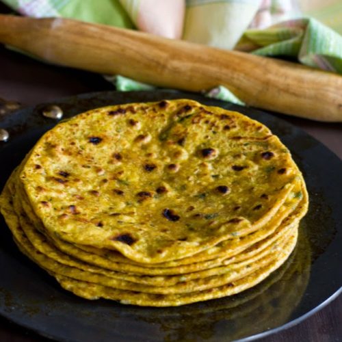 methi thepla,an Indian flatbread stacked and served with buttermilk and pickles