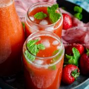 easy fresh strawberry lemonade served in tin can style glasses placed on a metal tray with fresh strawberries and a pink linen cloth around it