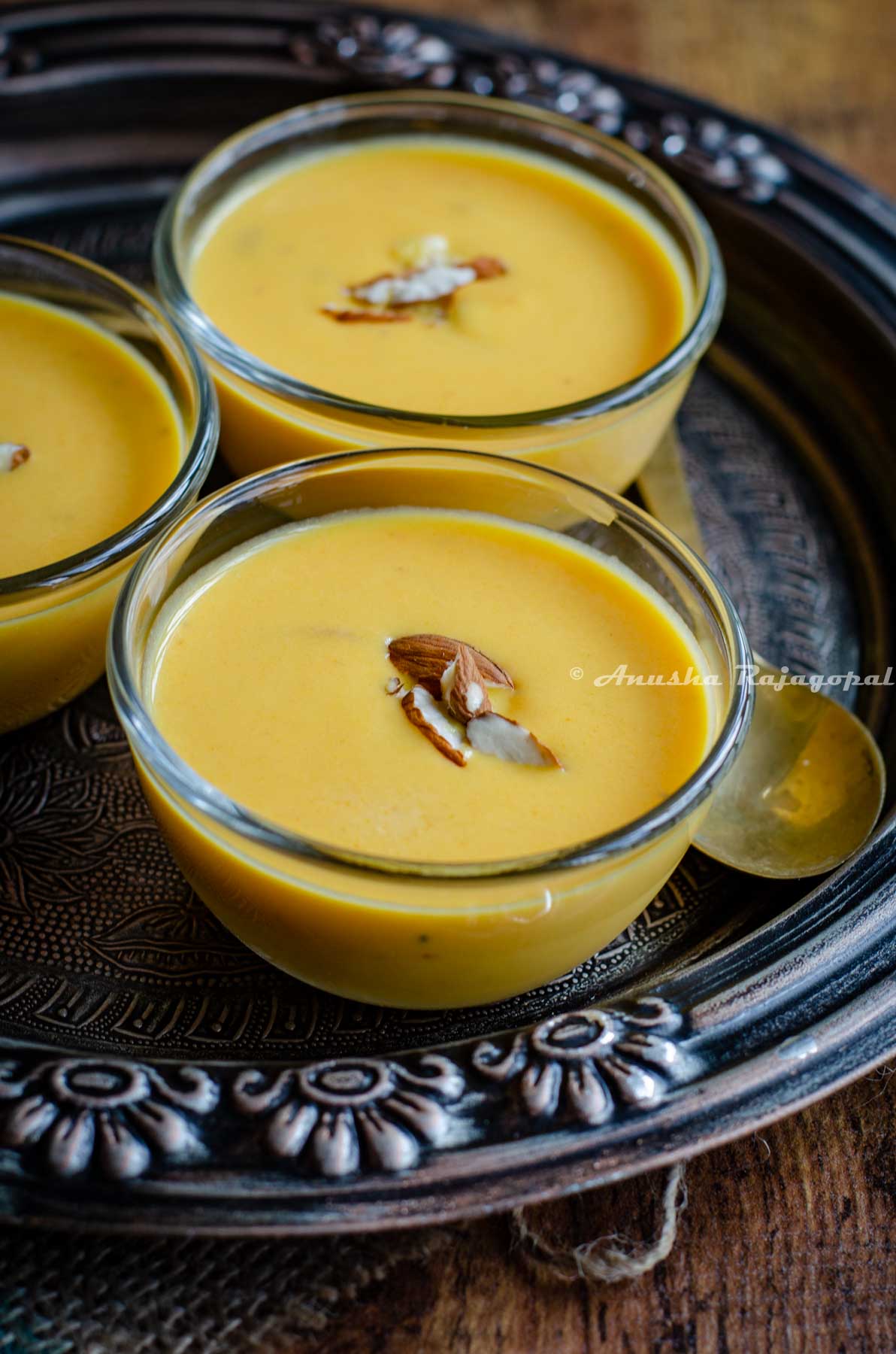 Instant pot carrot kheer served in glass bowls placed over a metallic tray. Kheer is topped with chopped almonds.