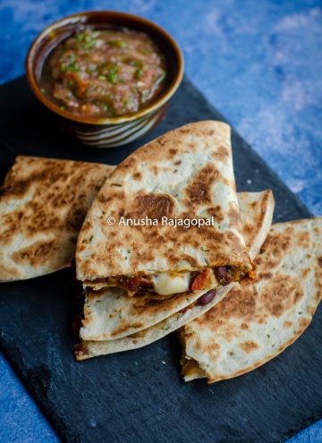 kidney bean quesadilla served with a tomato salsa on a slate board