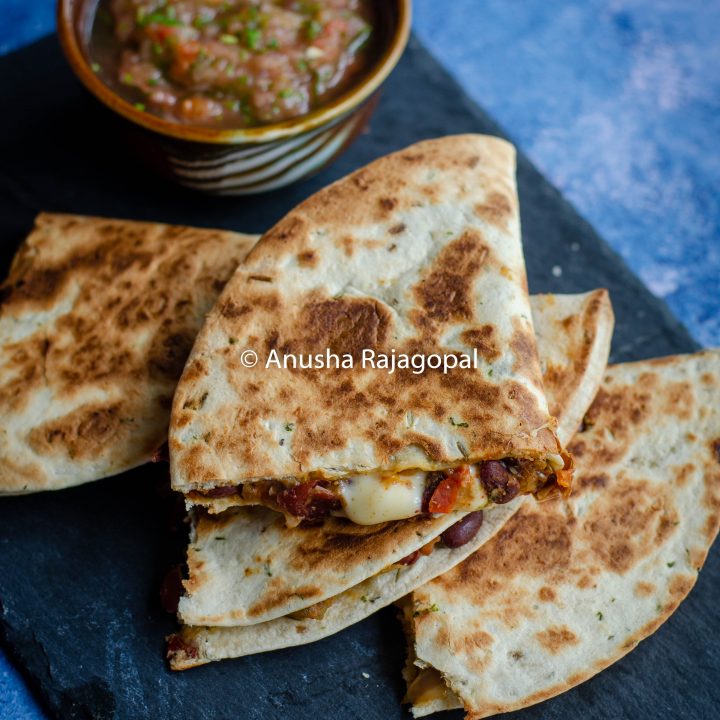 kidney bean quesadilla served with a tomato salsa on a slate board
