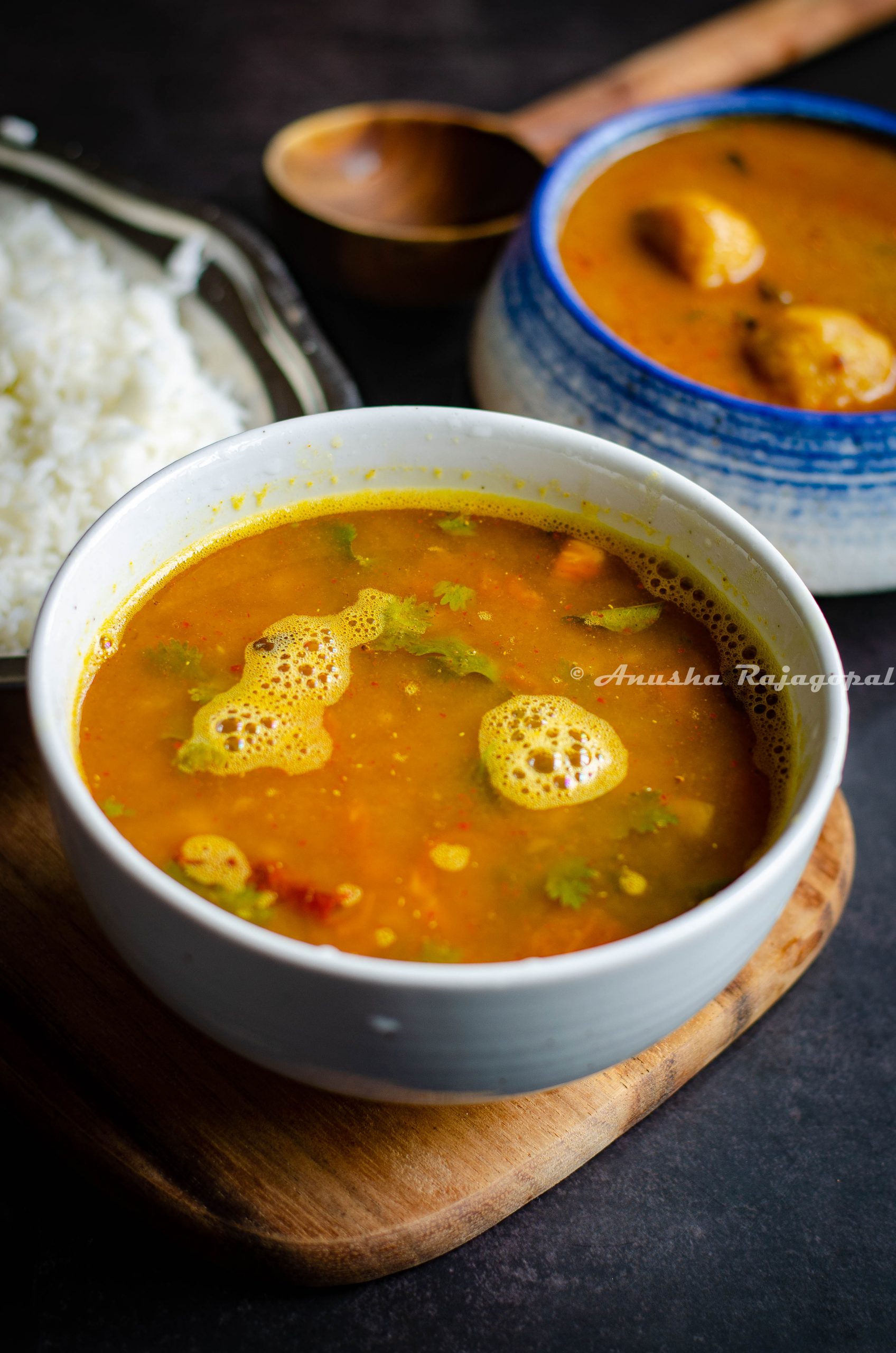 pineapple rasam served in a white bowl placed on a wooden board