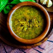 Spinach garlic dal served in a wooden bowl placed on a wooden plate