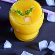 mango peach smoothie served with ice cubes around it