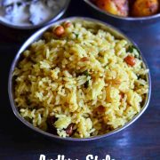 andhra style puliogare presented in a triangular bowl alongside roasted baby potatoes and yogurt sauce