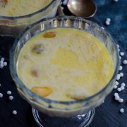 Sabudana kheer- a creamy indian dessert made with sago pearls and milk. Served in a glass bowl placed on slate board.