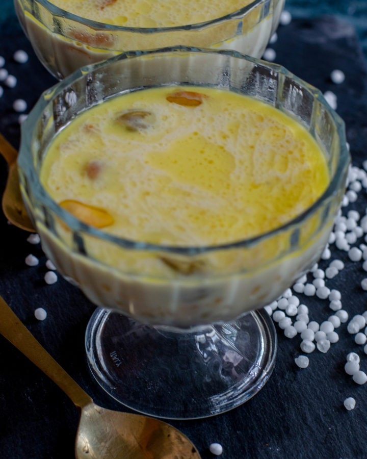 Sabudana kheer- a creamy indian dessert made with sago pearls and milk. Served in a glass bowl placed on slate board.