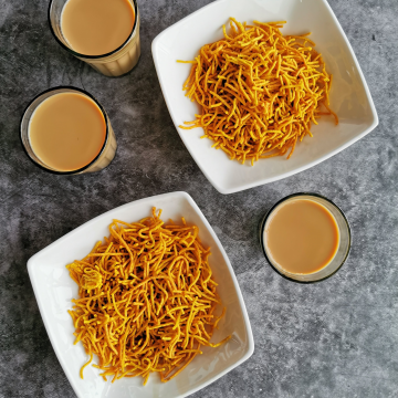 Aloo Bhujia- Potato sev served in white bowls with chai