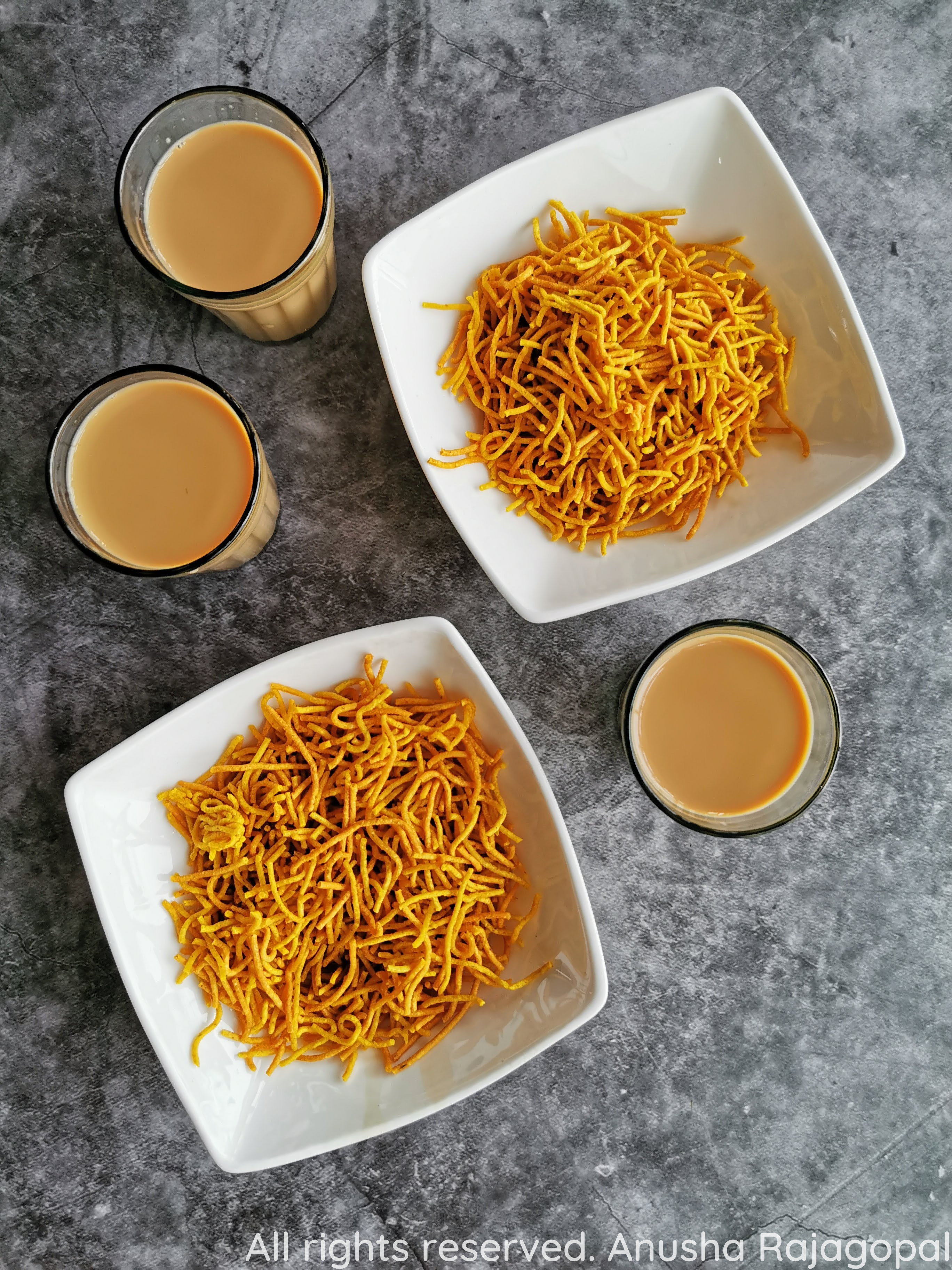 Aloo Bhujia- Potato sev served in white bowls with chai