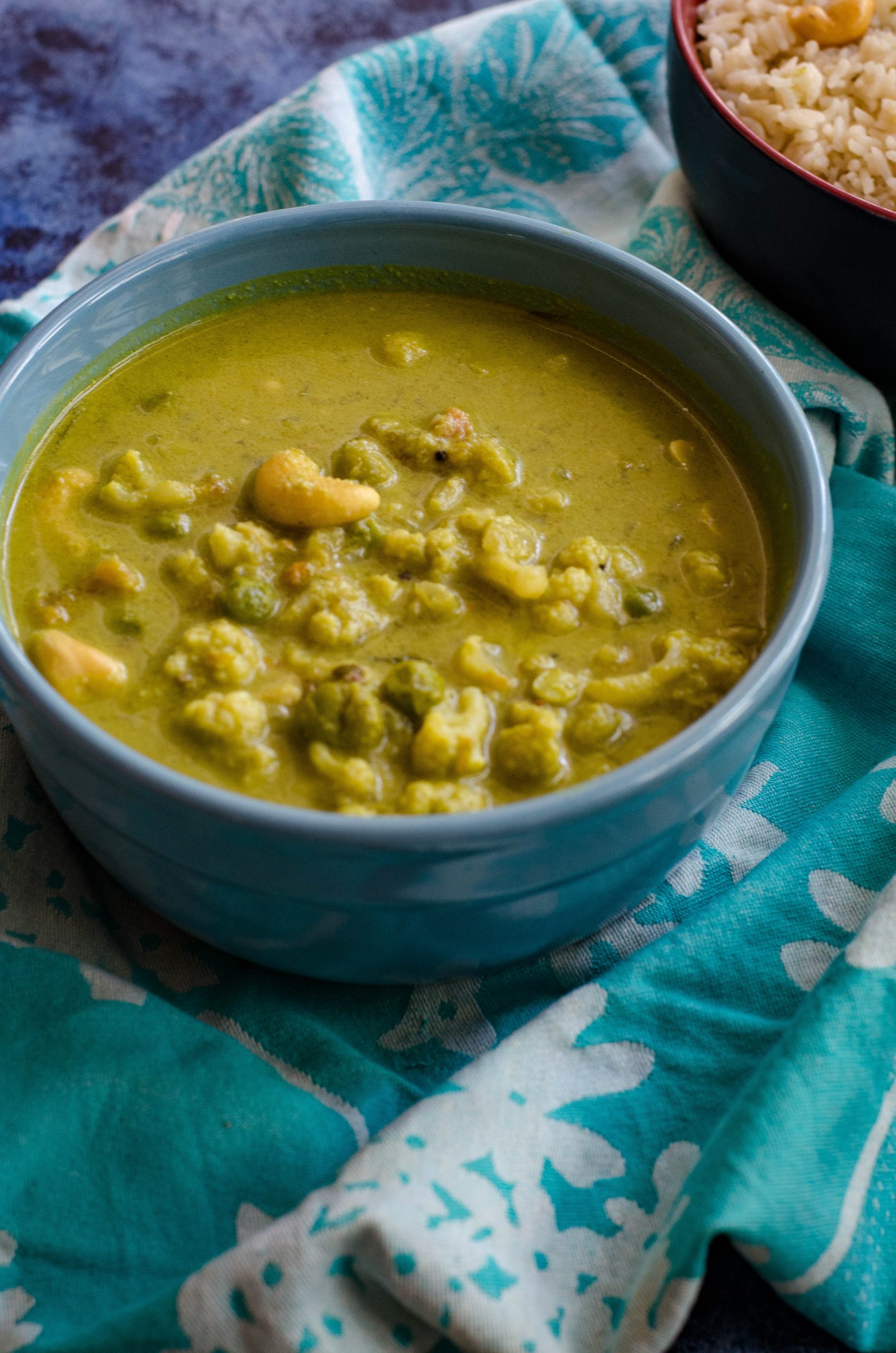 cauliflower cashew curry served in a blue bowl