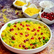 delicious kanda batata poha served in a white bowl with toppings