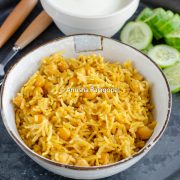 chana pulao in mealthy served in a beige bowl with cukes and raita.