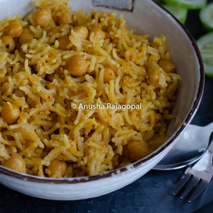 chana pulao in mealthy served in a beige bowl with cukes and raita.