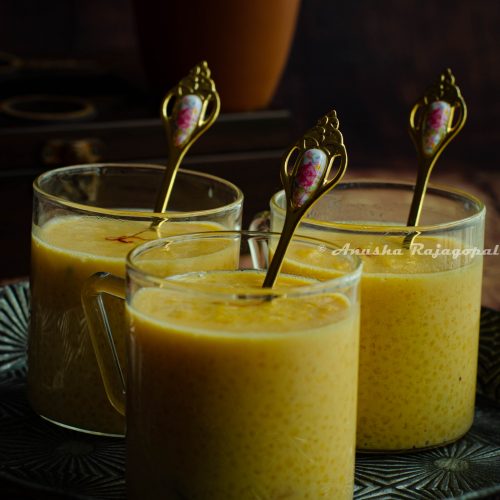 Little millet kheer served in glass mugs with tiny golden spoons in them.