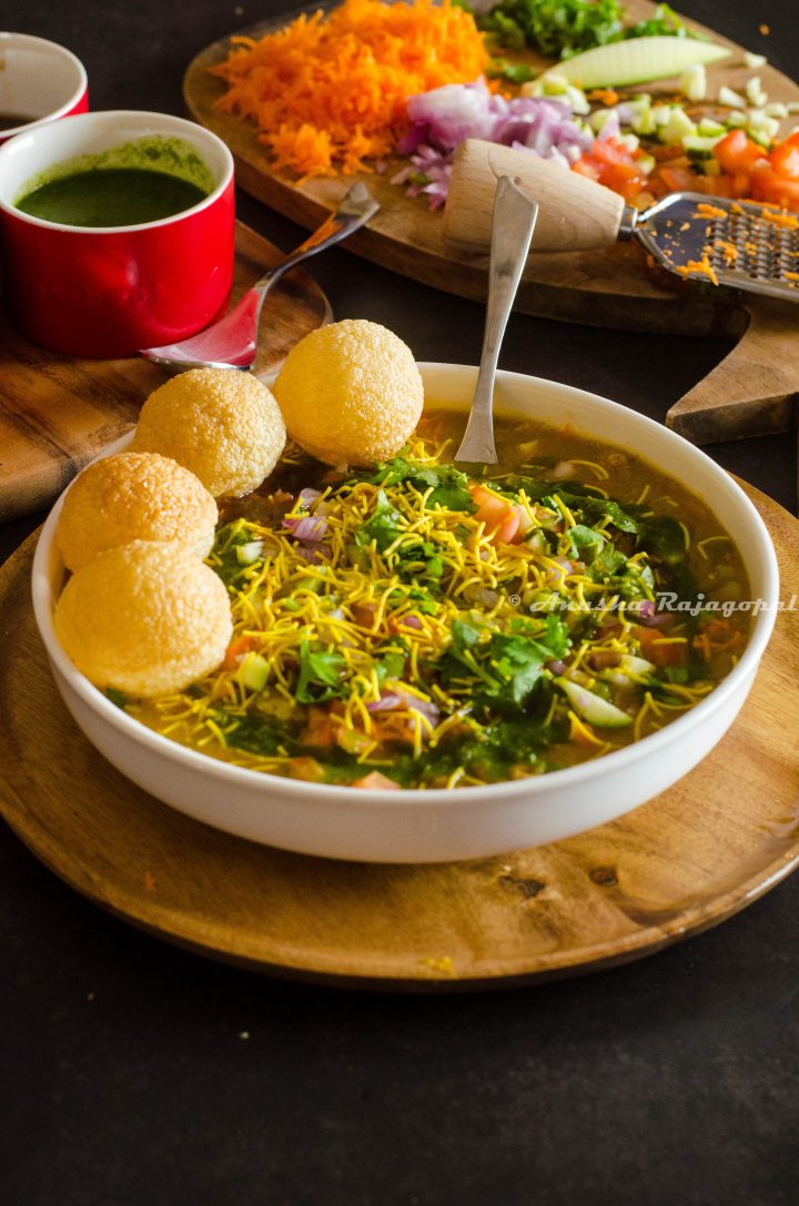 a bowl of bangalore style masala puri chaat served over a wooden plate. 
