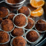 chocolate orange truffles in liners stacked on a vintage metal plate