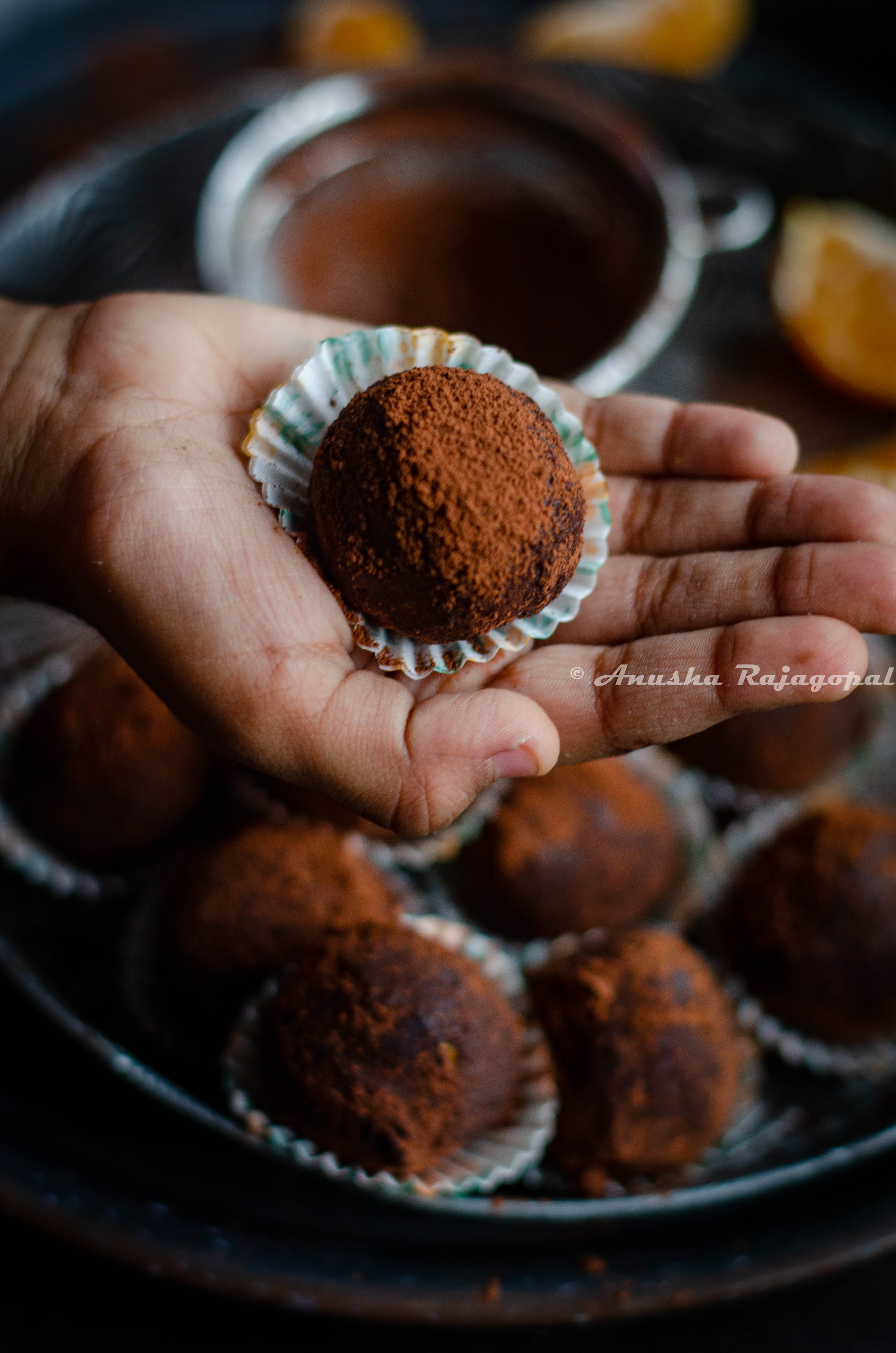 chocolate orange truffles in liners stacked on a vintage metal plate