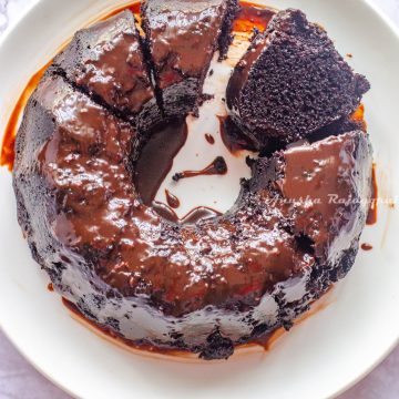black magic cake glazed and sliced . served on a white plate
