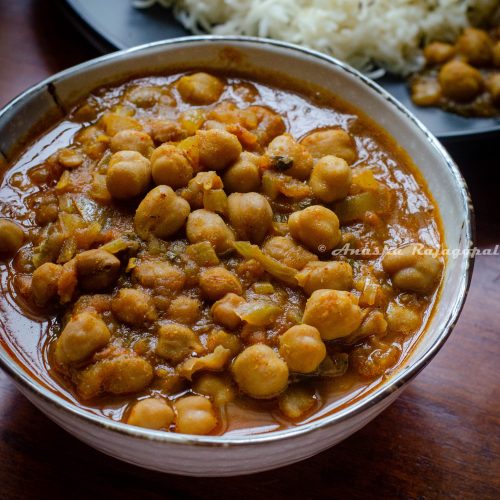 Punjabi chole masala served in a white bowl with steamed rice