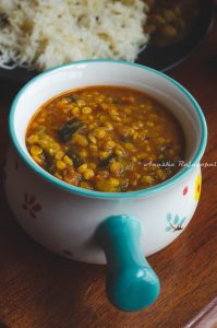 Instant pot zucchini channa dal served in a white bowl with a blue handle.