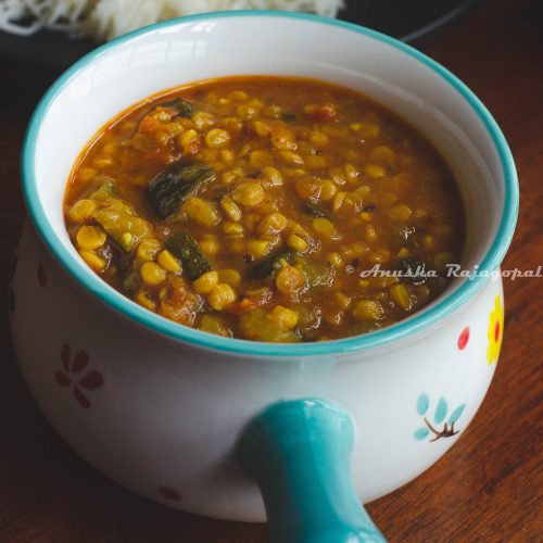 Instant pot zucchini channa dal served in a white bowl with a blue handle.