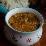 Instant pot zucchini channa dal served in a white bowl with a blue handle.