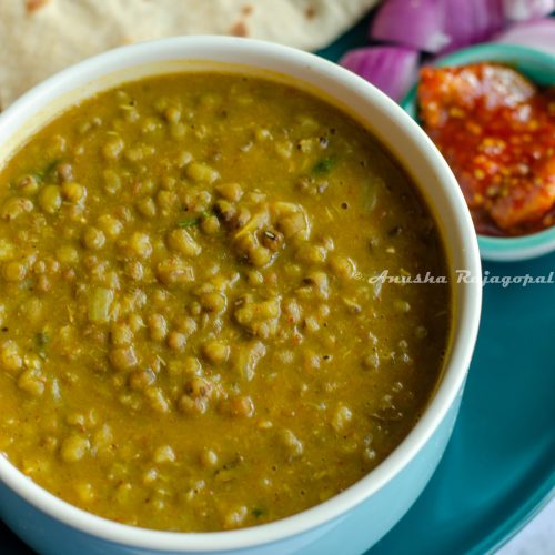 Instant pot green moong dal served in a blue bowl with rotis