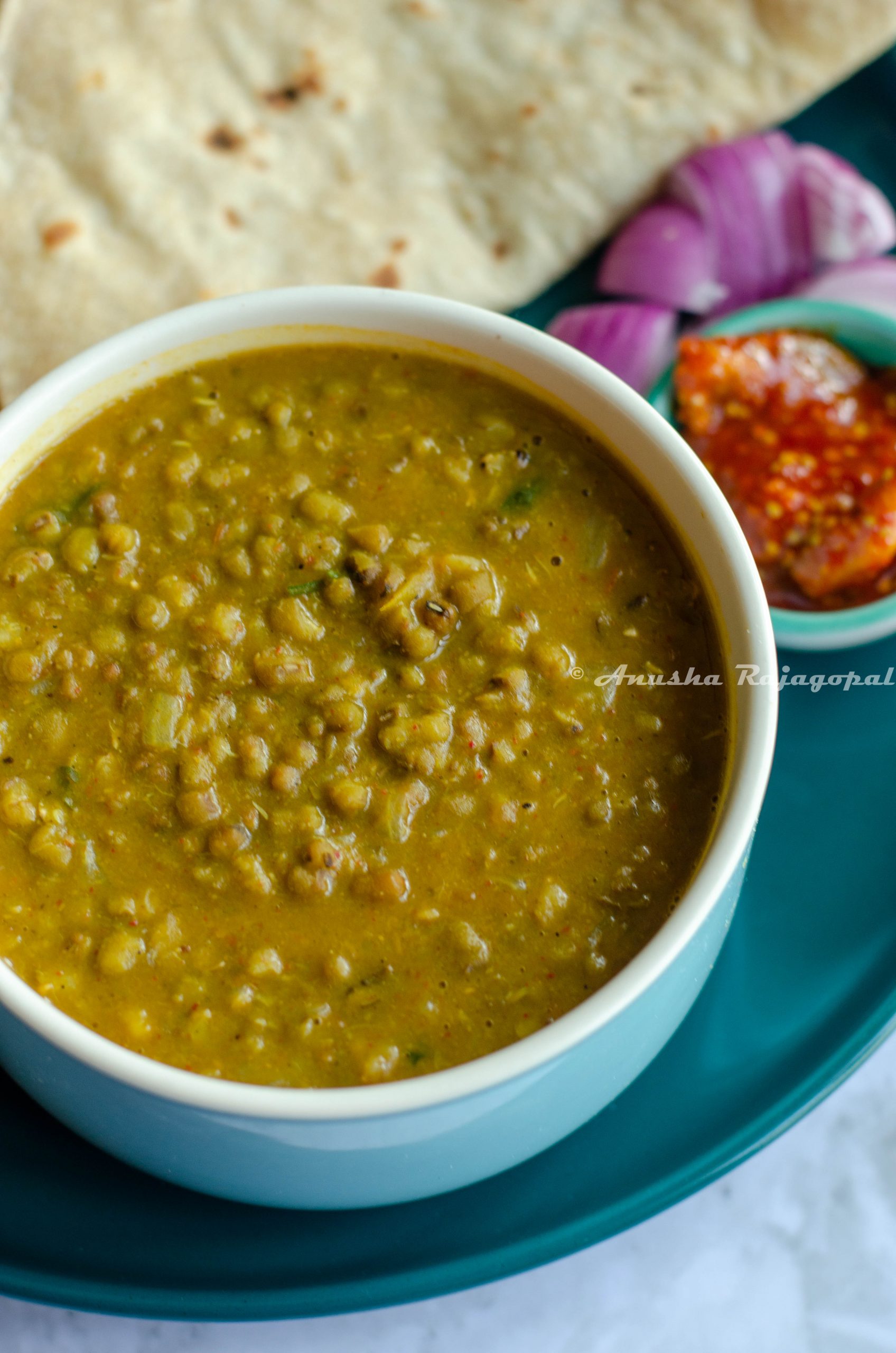 Instant pot green moong dal served in a blue bowl with rotis