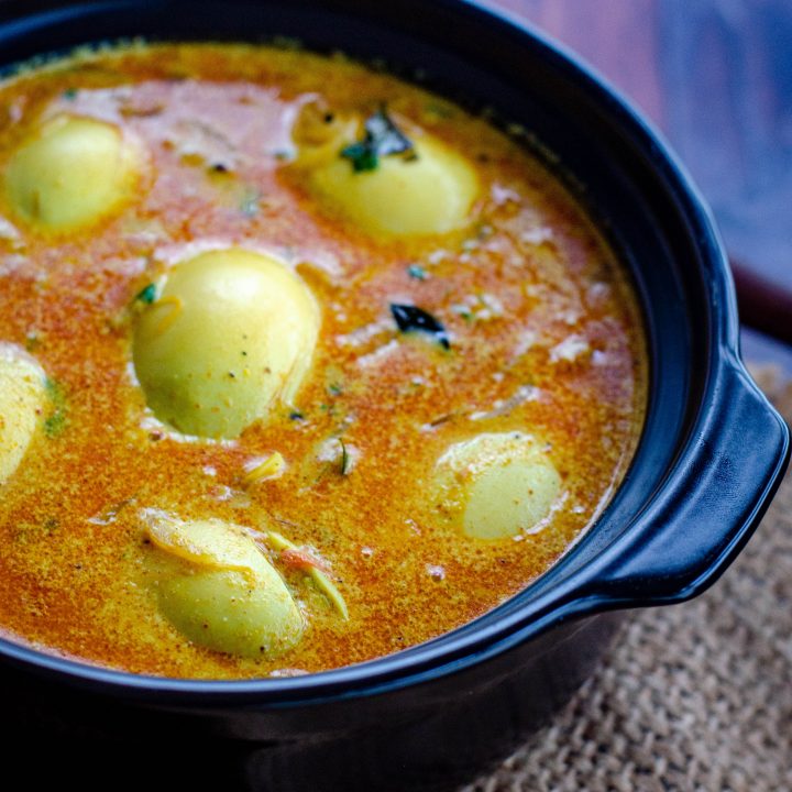 kerala egg curry served in a black bowl placed on a burlap mat