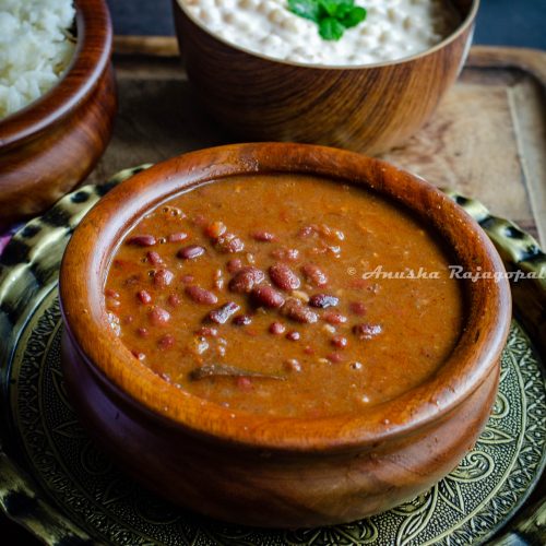Indian style kidney beans curry served in a wooden bowl placed on a brass plate