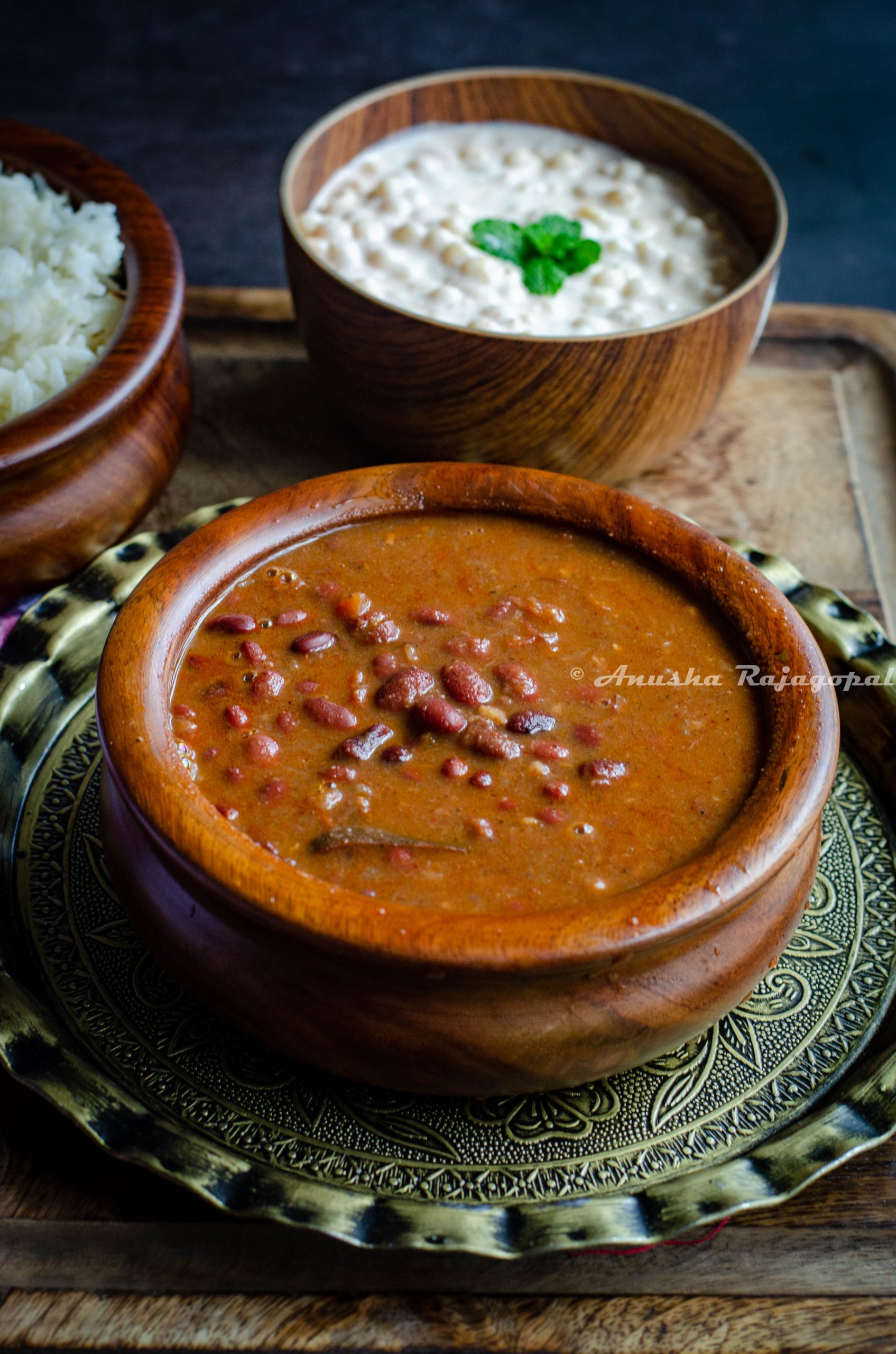 Indian style kidney beans curry served in a wooden bowl placed on a brass plate