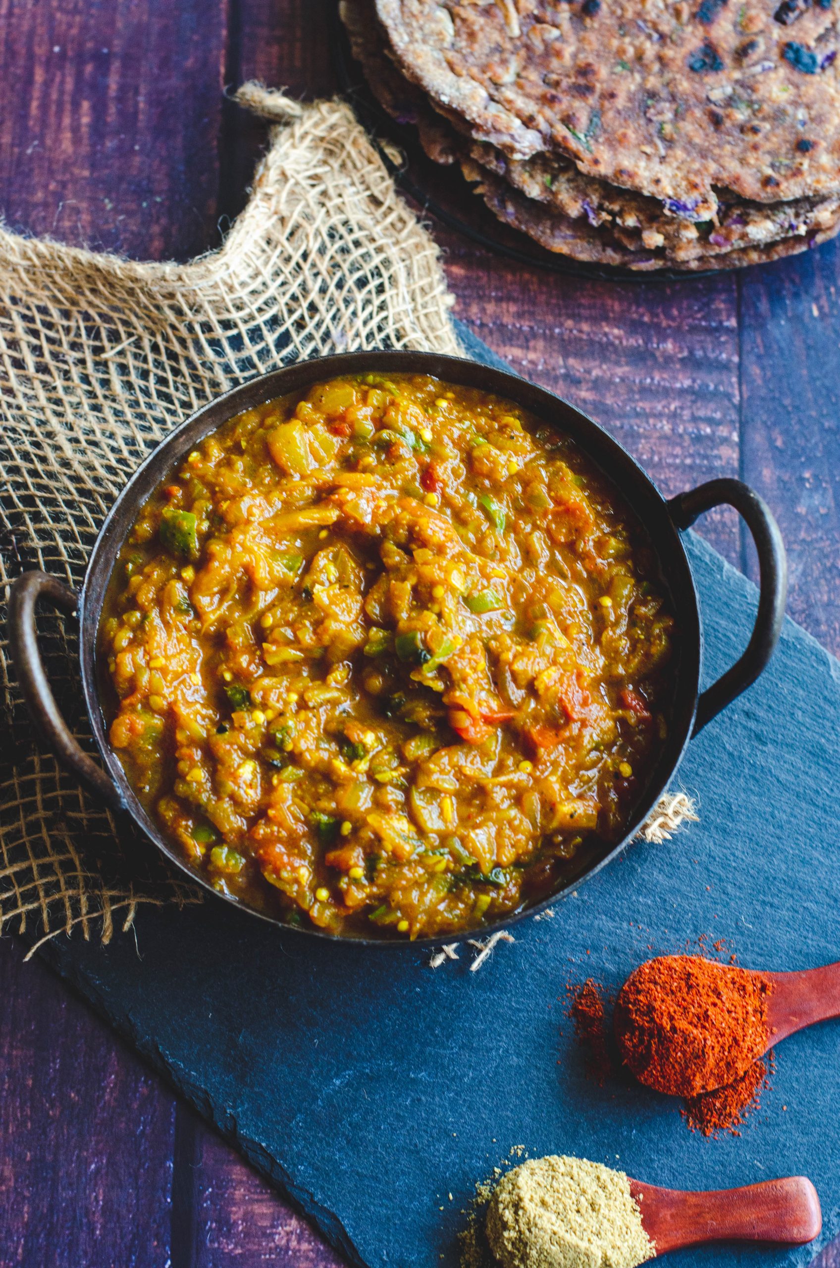 Baingan bartha served in an Indian Karahi placed on a burlap mat.