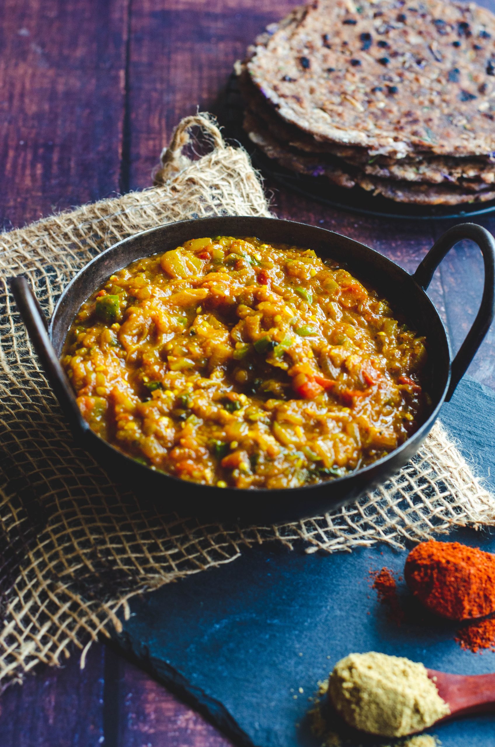 Baingan bartha served in an Indian Karahi placed on a burlap mat.