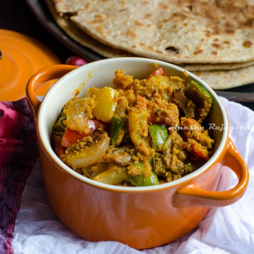 capsicum zunka served in a orange ceramic casserole with parathas