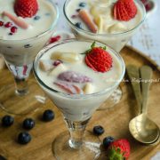 fruit custard without custard powder served in glasses placed on a wooden plate