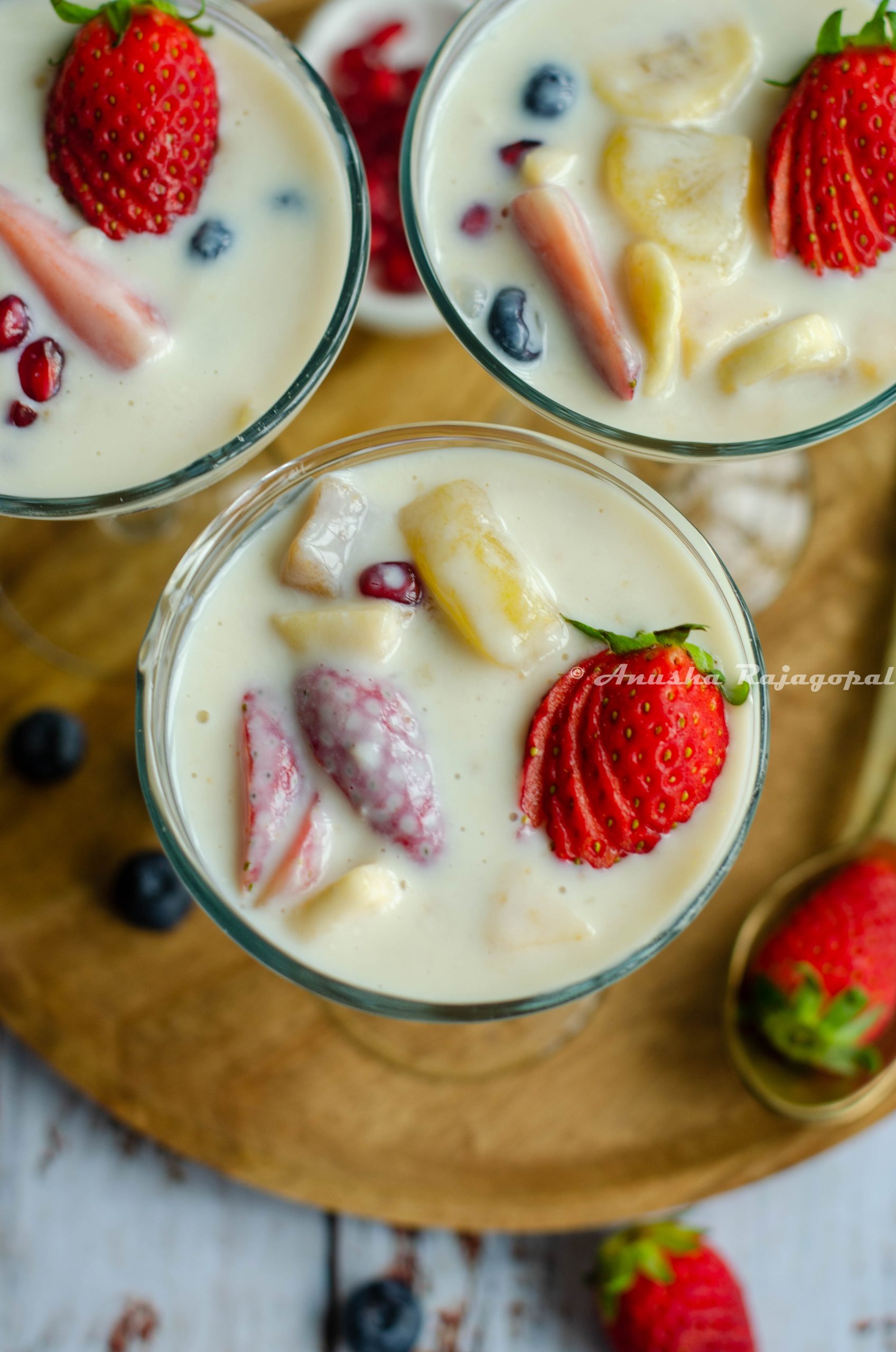 fruit custard without custard powder served in glasses placed on a wooden plate