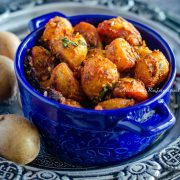 Jodhpuri aloo served in a blue casserole bowl placed over a silver plate