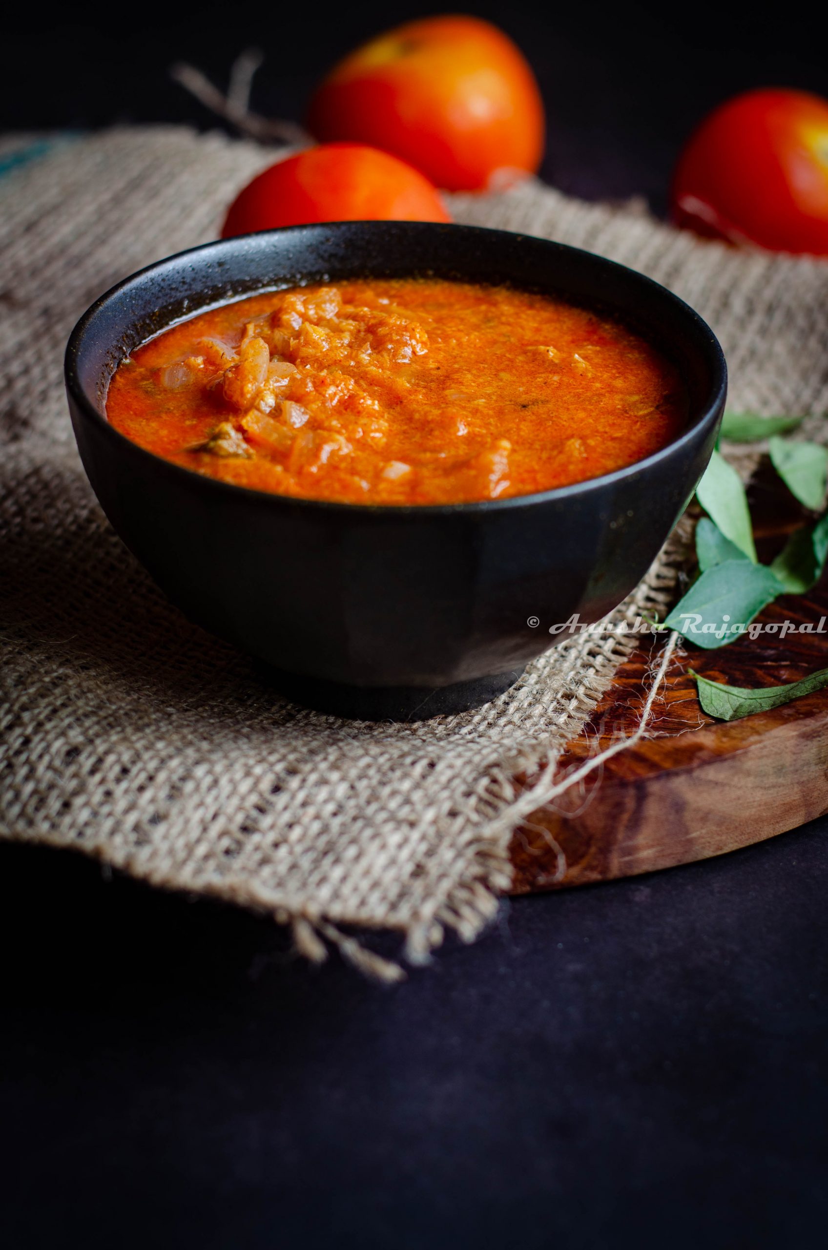 Tomato kurma, a south Indian curry served in a black bowl