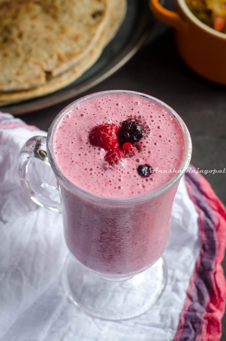 vegan berry rose lassi served in a tall glass placed on a cotton towel