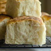 vegan dinner rolls stacked on a cooling rack