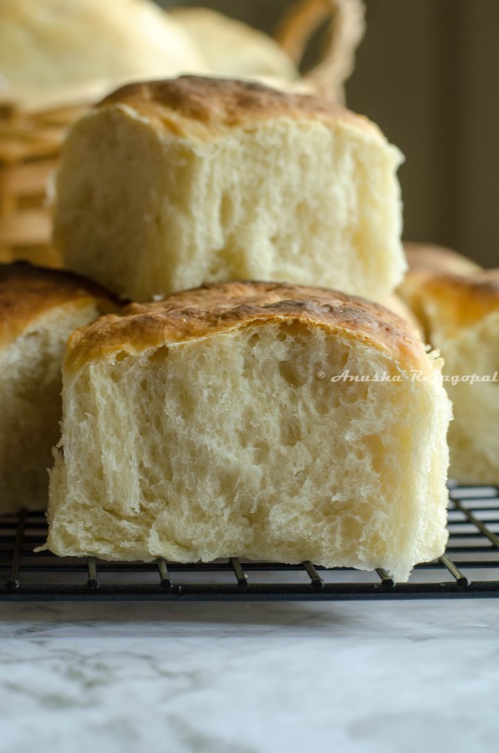 vegan dinner rolls stacked on a cooling rack