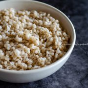 pearl barley cooked in instant pot and served in a white bowl placed over a grey backdrop