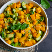 Mango avocado salad served in a white deep plate placed on a burlap mat. Mango cubes in a bowl, herbs and avocado by the sides