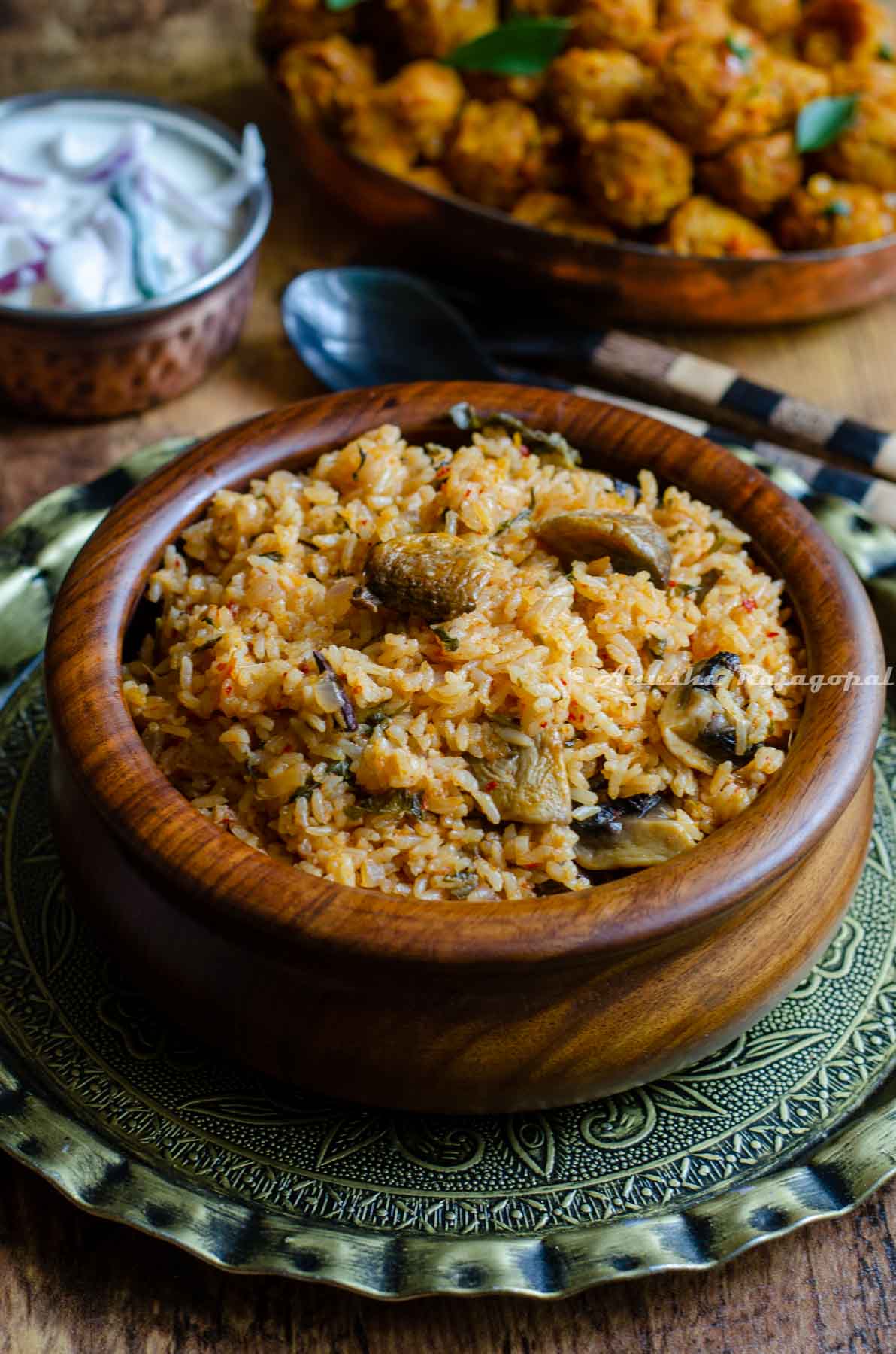seeraga samba biryani served in a wooden bowl placed over a brass plate