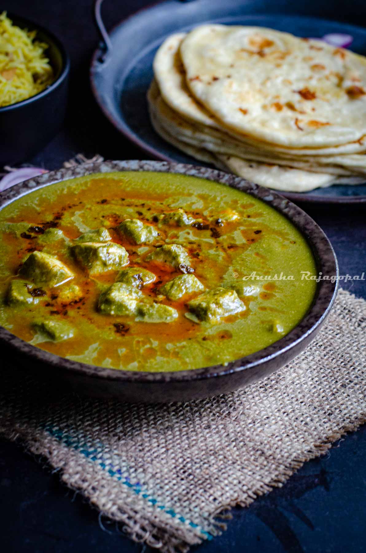 instant pot palak paneer served in a black bowl.