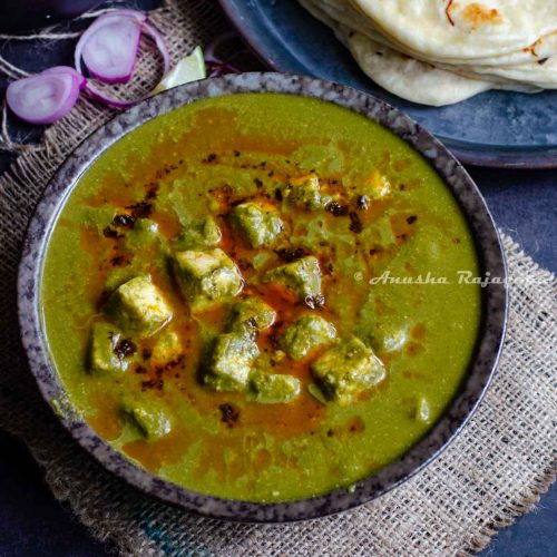 Palak paneer made in Instant Pot served in a black bowl placed over a burlap mat.