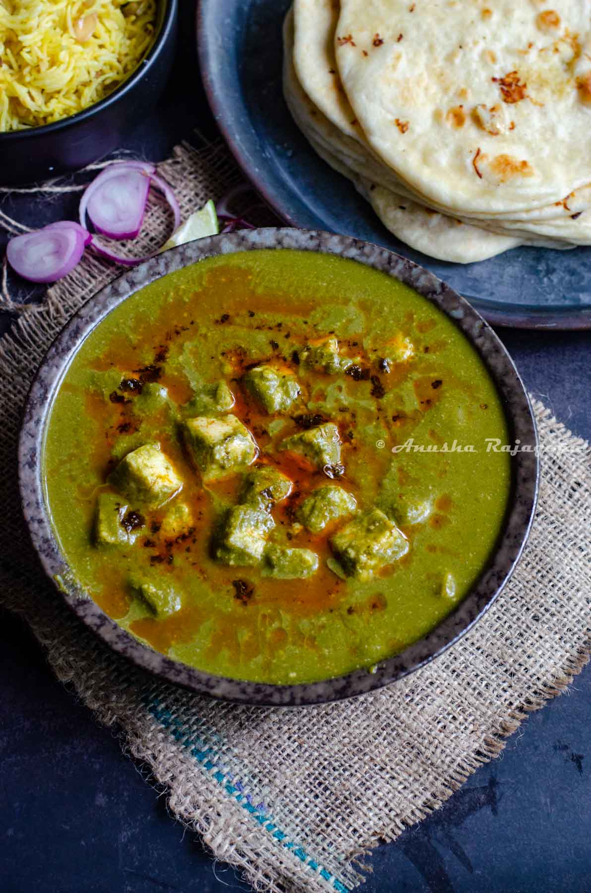 Palak paneer made in Instant Pot served in a black bowl placed over a burlap mat.