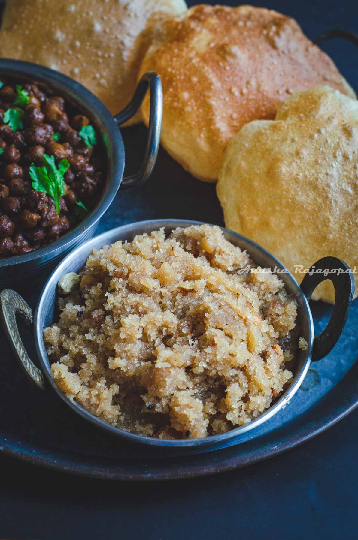 Sooji ka Halwa served on a grey platter with poori and kala chana